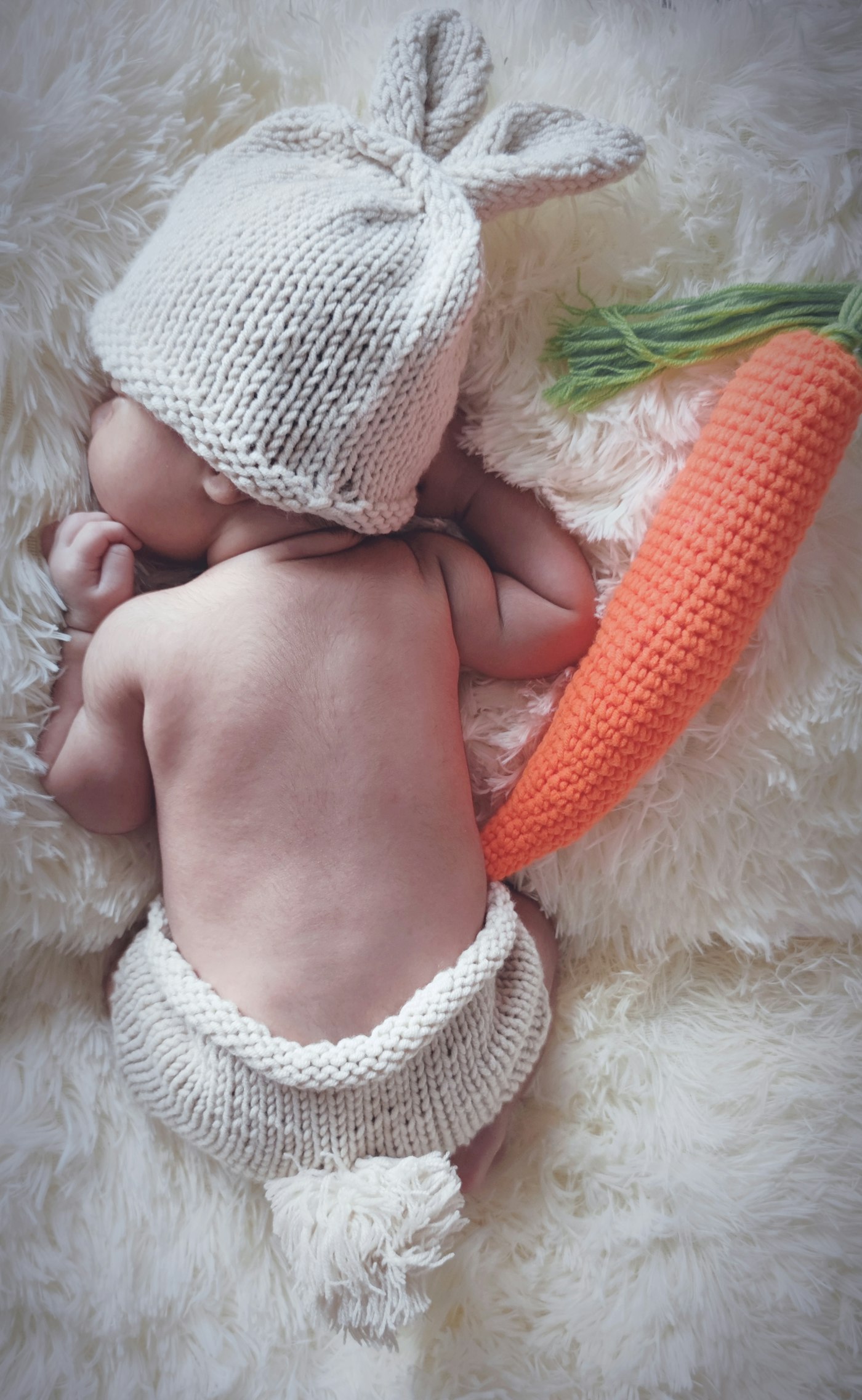 Newborn wearing a soft white knit cap