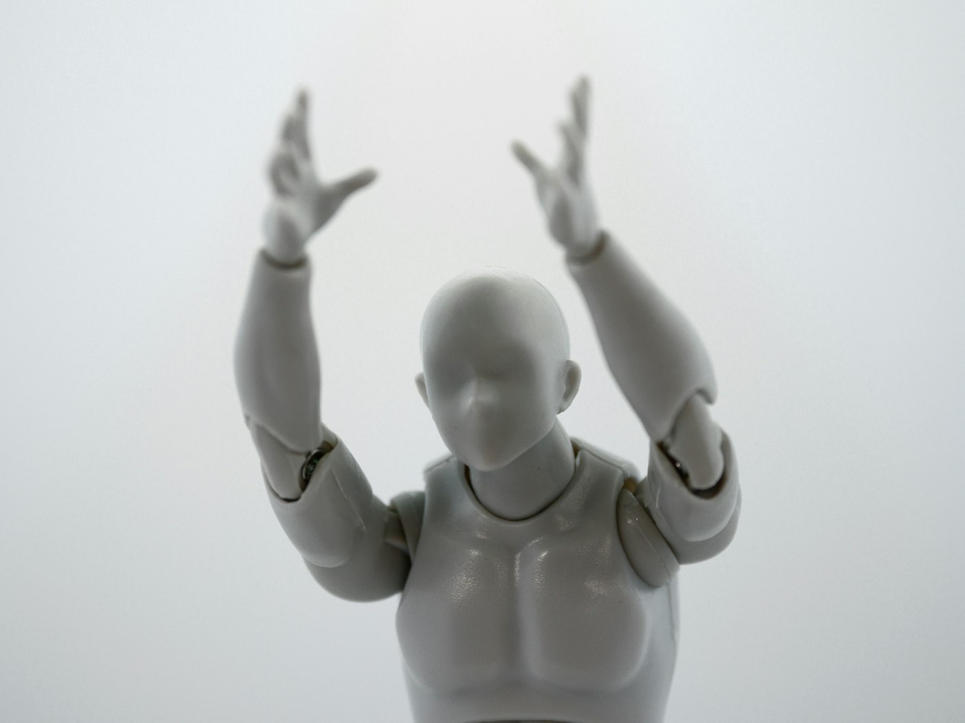 Baby in a white cotton bodysuit lying on a soft white sheet