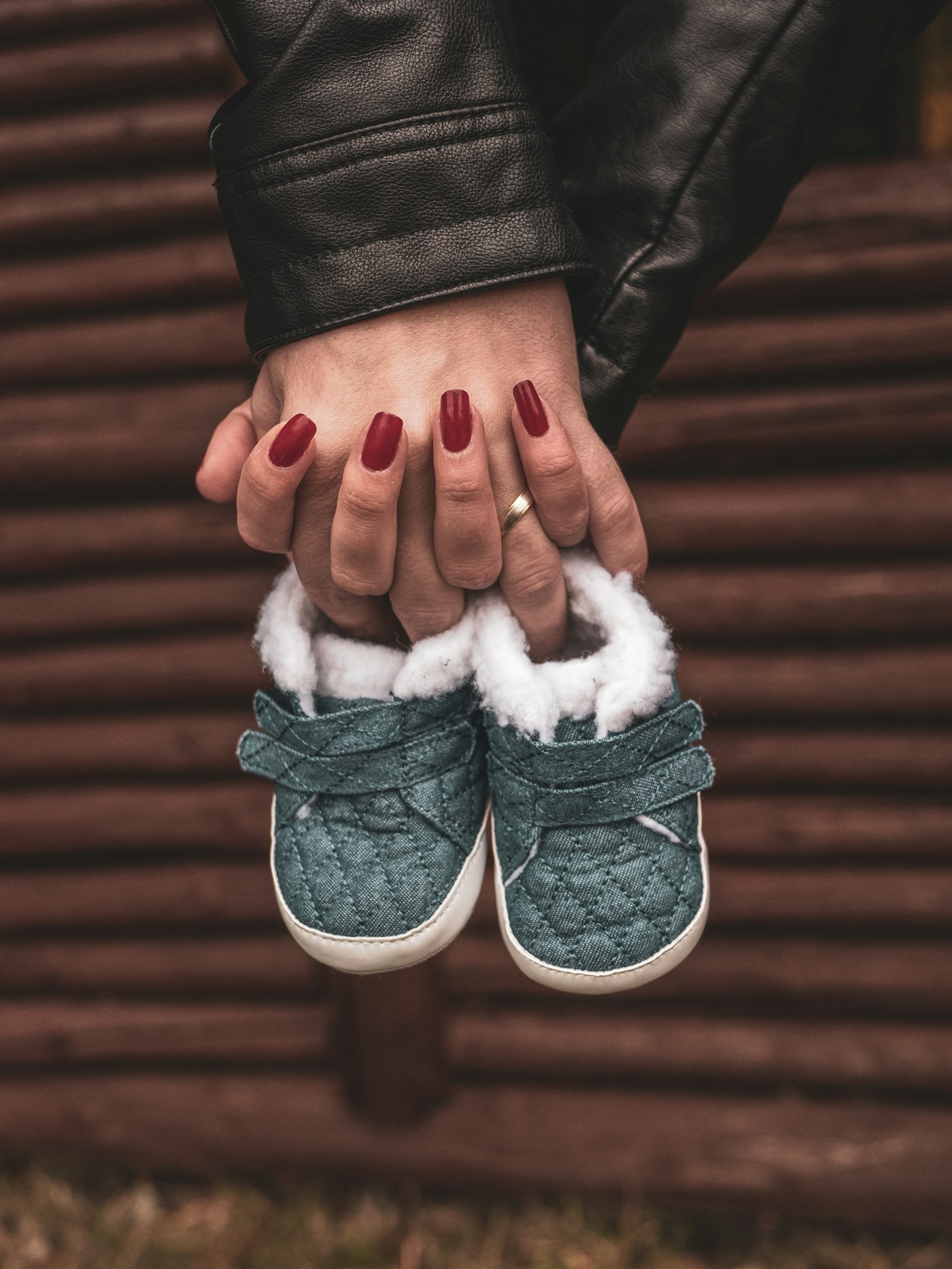 Parents holding a tiny pair of soft baby shoes